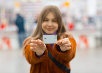 lány bankkártyával a kezében