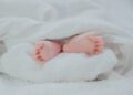 kisbaba lábak kilógva a takaró alól