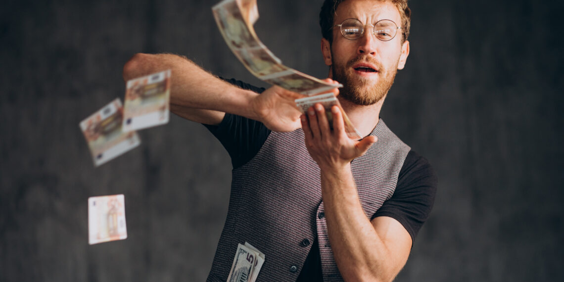 férfi papírpénzt szór a levegőbe